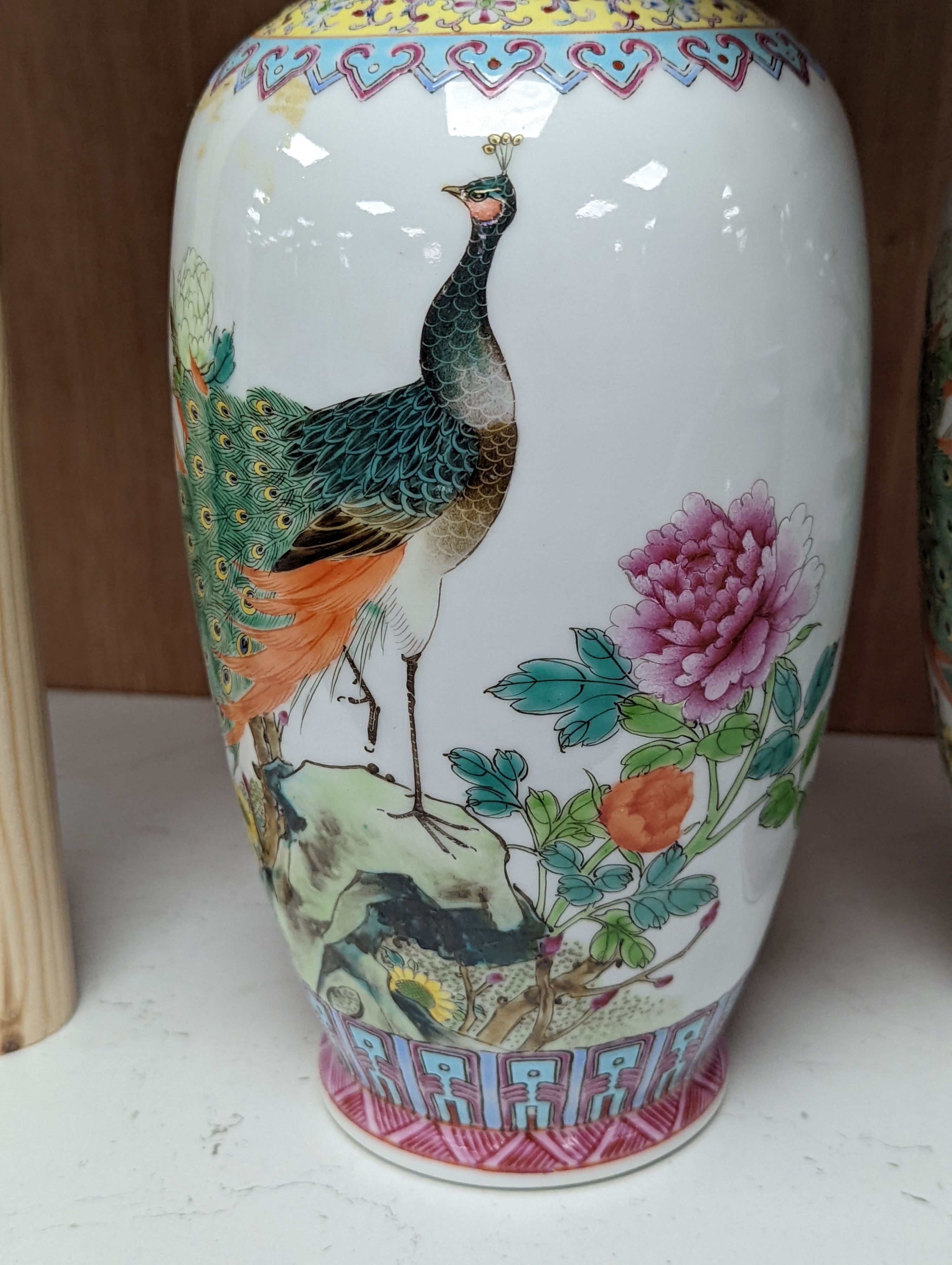 A pair of Chinese famille rose vases decorated with peacocks, 31cm